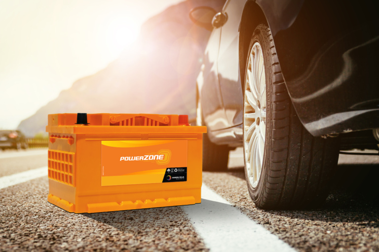 A set of high-performance summer tyres and a powerzone car battery displayed together, representing essential UAE summer vehicle maintenance.