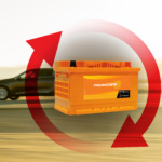 A bloated and swollen car battery casing caused by extreme summer heat and internal gas buildup in a desert climate.