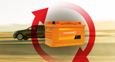 A bloated and swollen car battery casing caused by extreme summer heat and internal gas buildup in a desert climate.