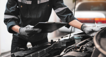 Technician installing Bosch wiper blades and performing a car AC gas refill for a vehicle in the UAE