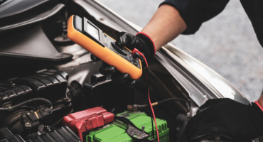 Mechanic testing a car battery weakened by UAE summer heat