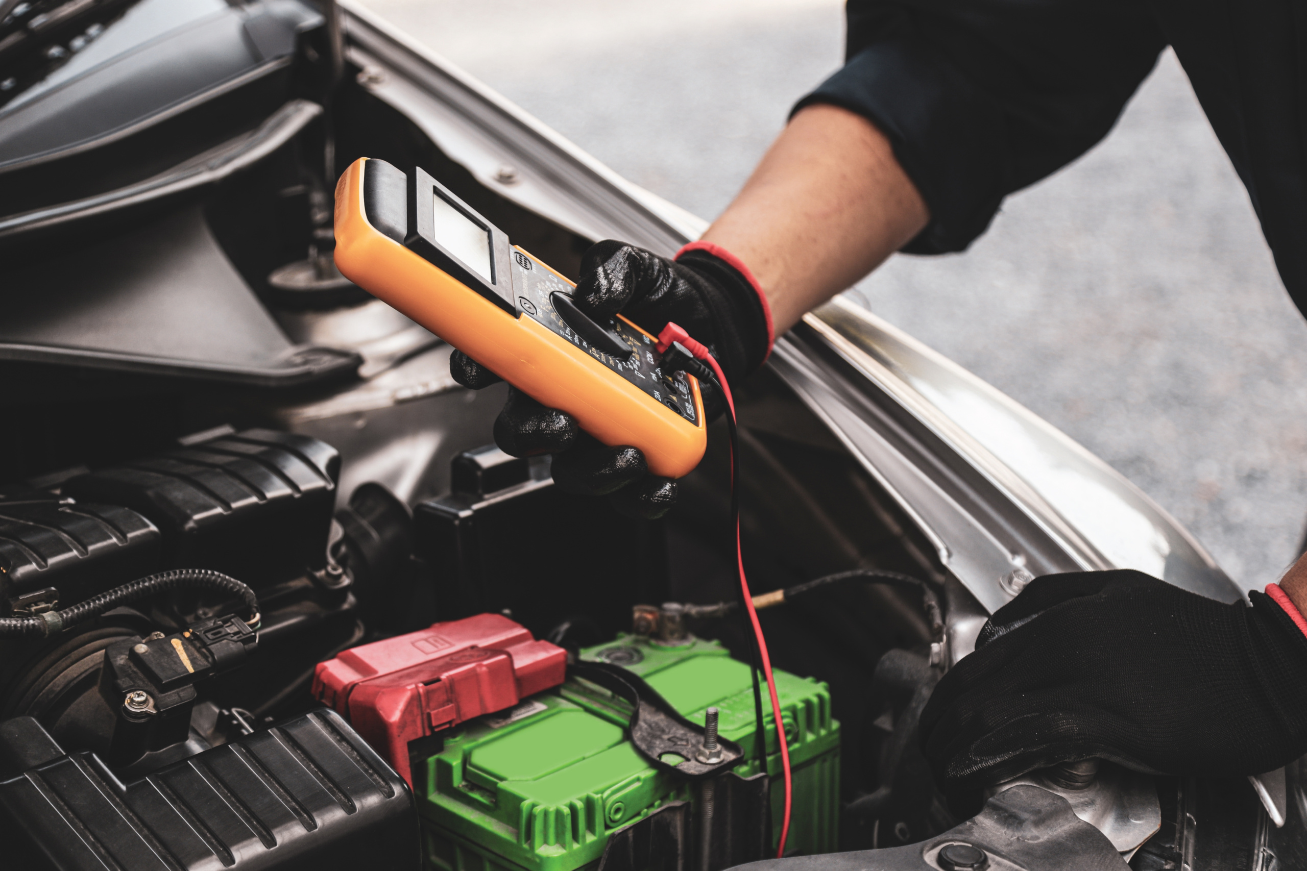 Mechanic testing a car battery weakened by UAE summer heat